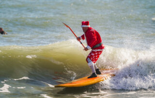 Frigid weather can’t stop Santas surfing off Florida coast