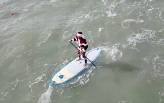 A Huge Crowd of Surfing Santas Paddled Out in Florida on Christmas Eve